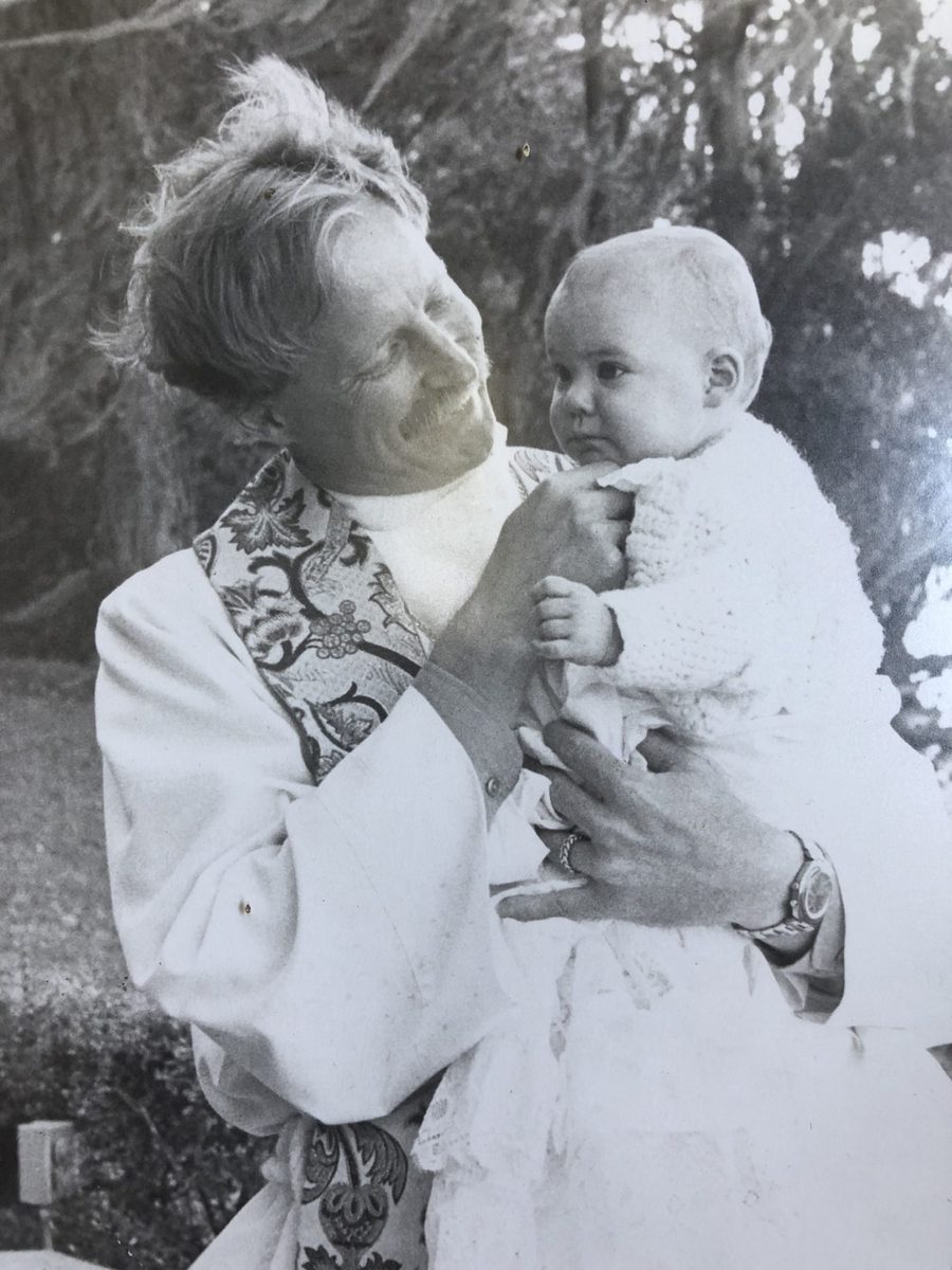 Rev. Robert V. Lee III as a young priest, holding an infant after a baptism.