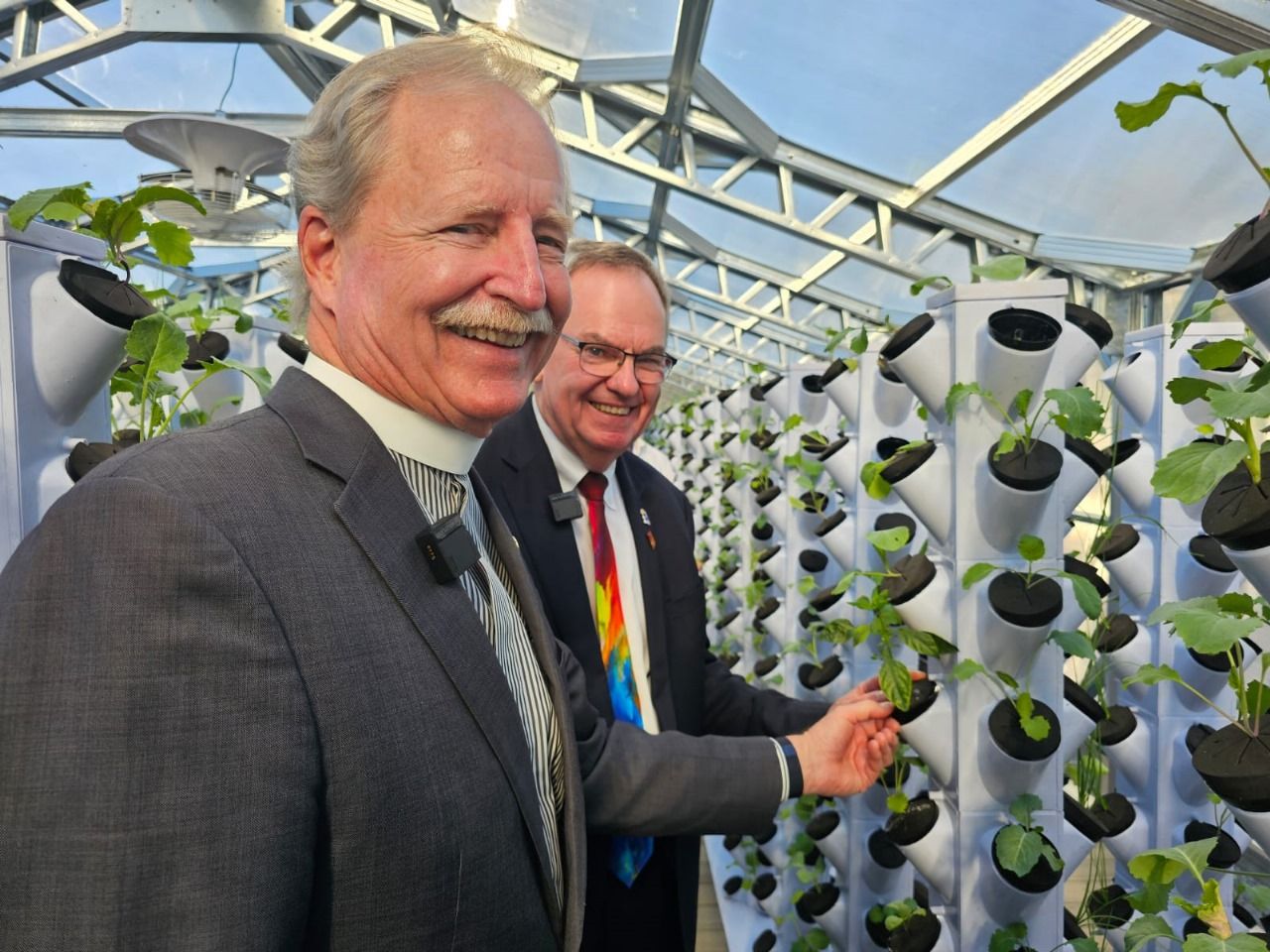 The Rev. Dr. Robert V. Lee III beside the growing towers in the aquaponics greenhouse.