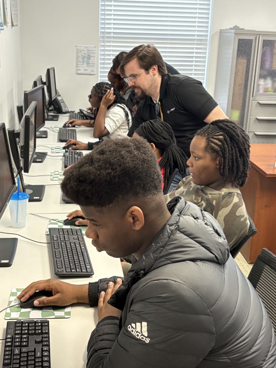 A mentor working beside a FreshFoundations student at the keyboard