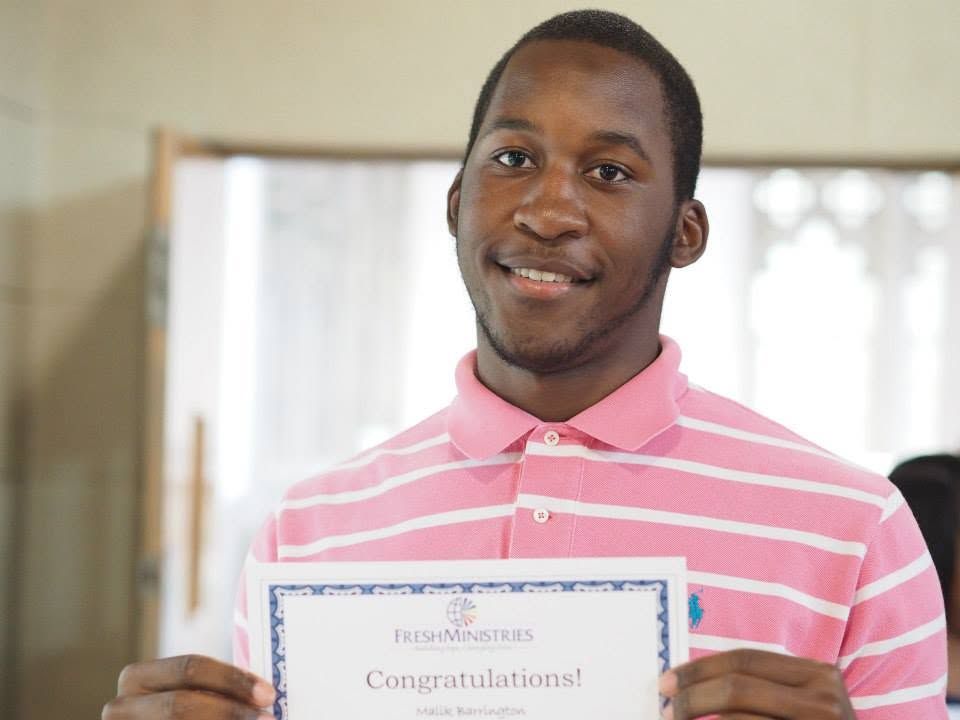 A FreshFutures student holding the certificate he earned for completing the program