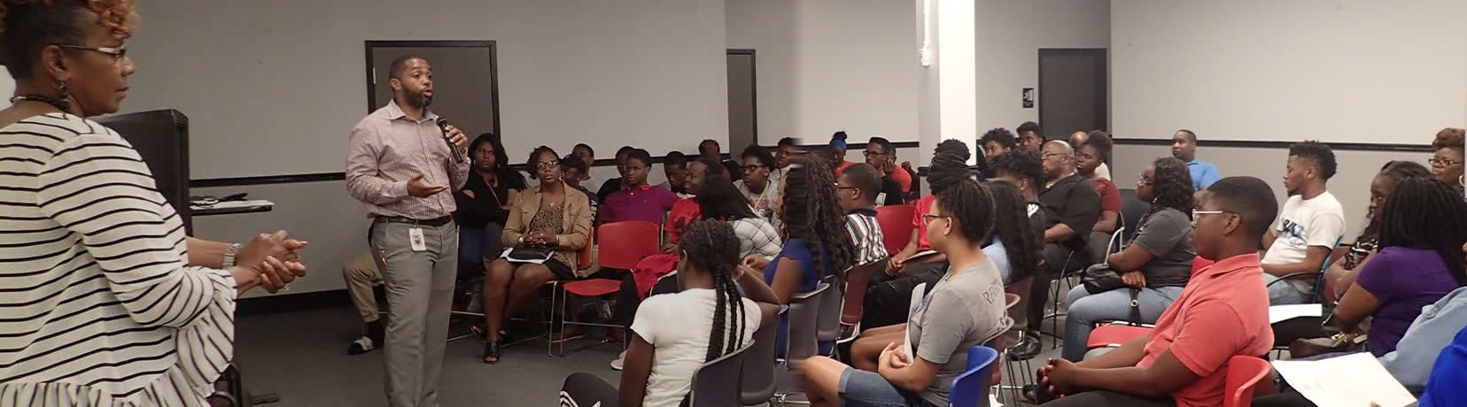 A FreshMinistries staff member leading a session for a room of young people and families.