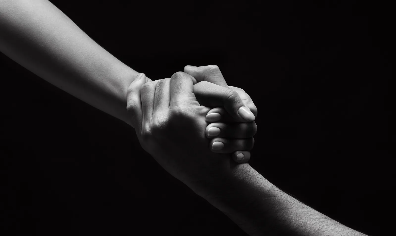 Two hands clasped together, one steadying the other