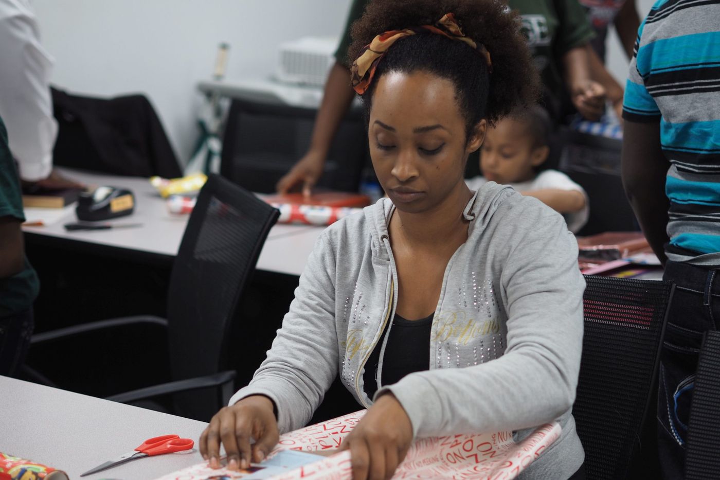 A volunteer wrapping donated gifts at a FreshMinistries holiday drive.